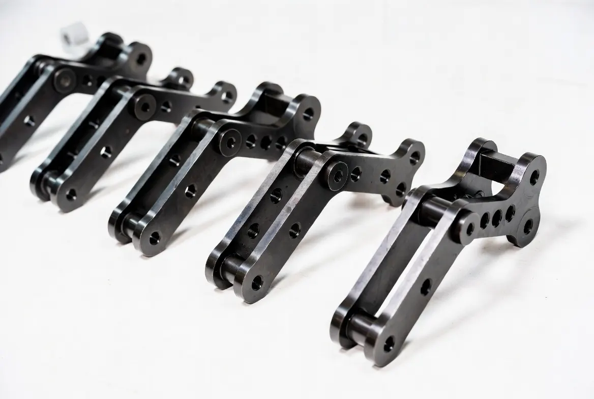 Multiple identical black oxide coated CNC steel industrial linkage connectors and pivot brackets arranged neatly in a row on a white background.