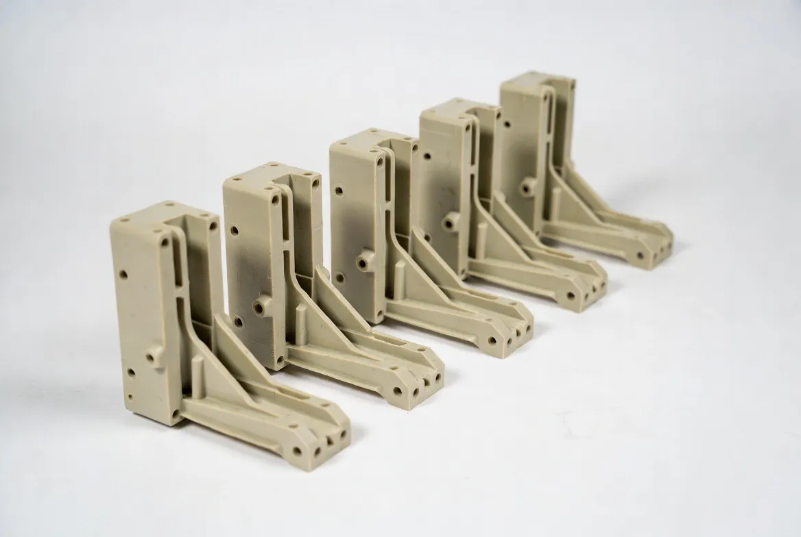 Multiple identical PA nylon CNC industrial structural brackets arranged neatly in a row on a white background.
