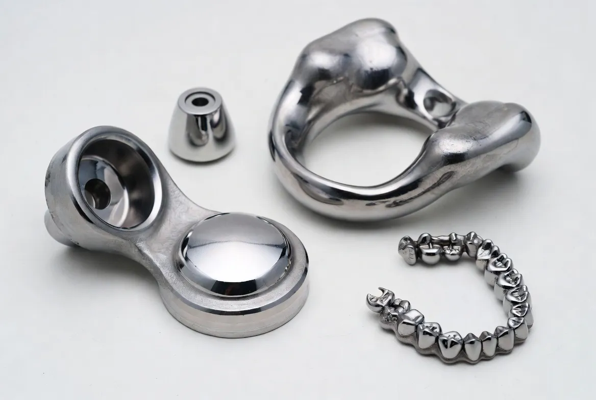 Cobalt-chrome alloy medical implants and dental frameworks: hip joint replacements, knee components and dental crowns with polished metallic finish on clean white background